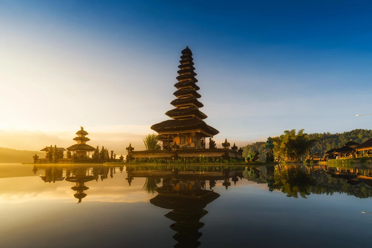 Ulun Danu temple complex reflecting in the calm waters of Lake Beratan Bali at sunrise